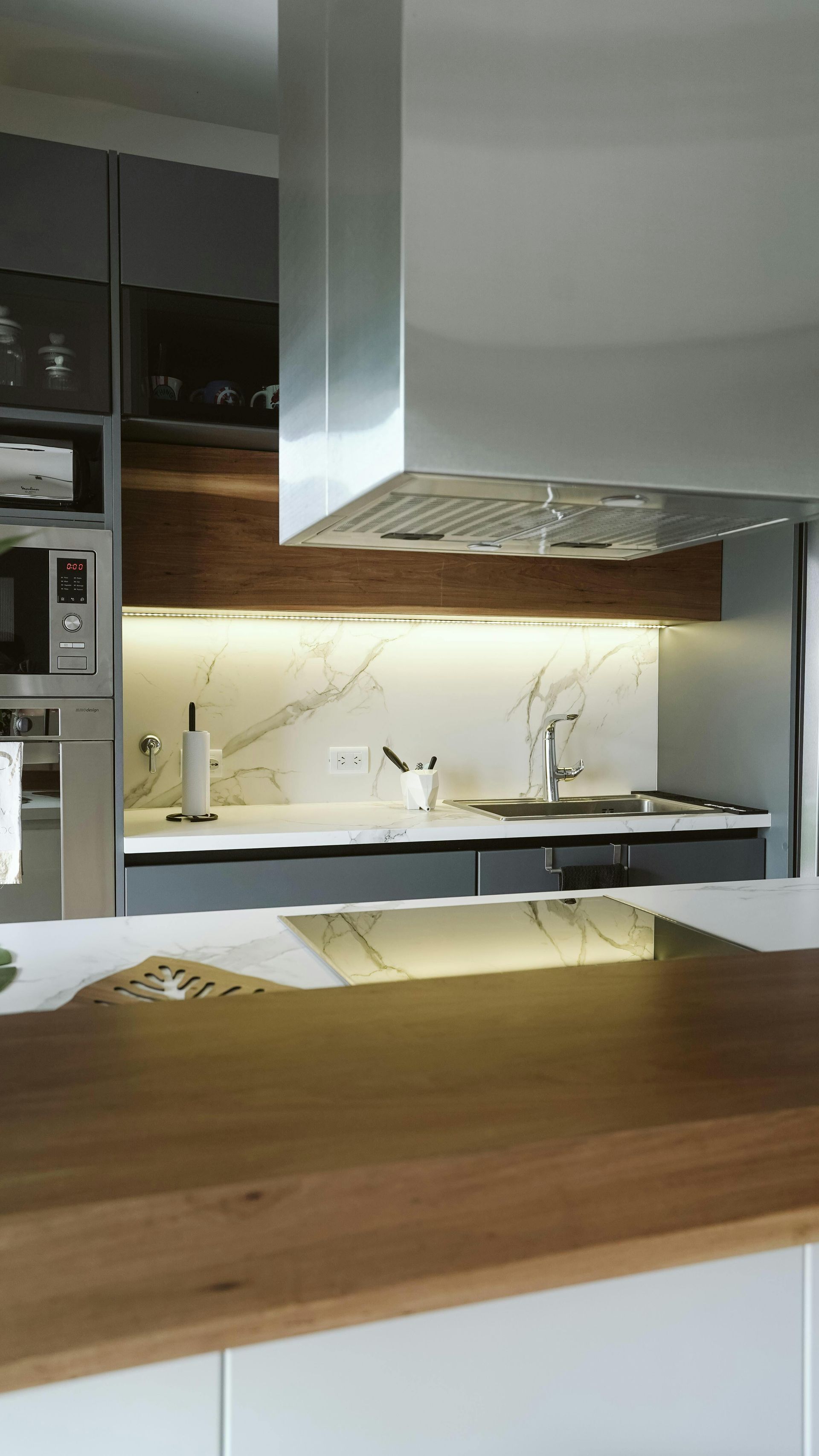 Gabinetes de cocina blancos que se instalan en una habitación con pisos de madera y una ventana.