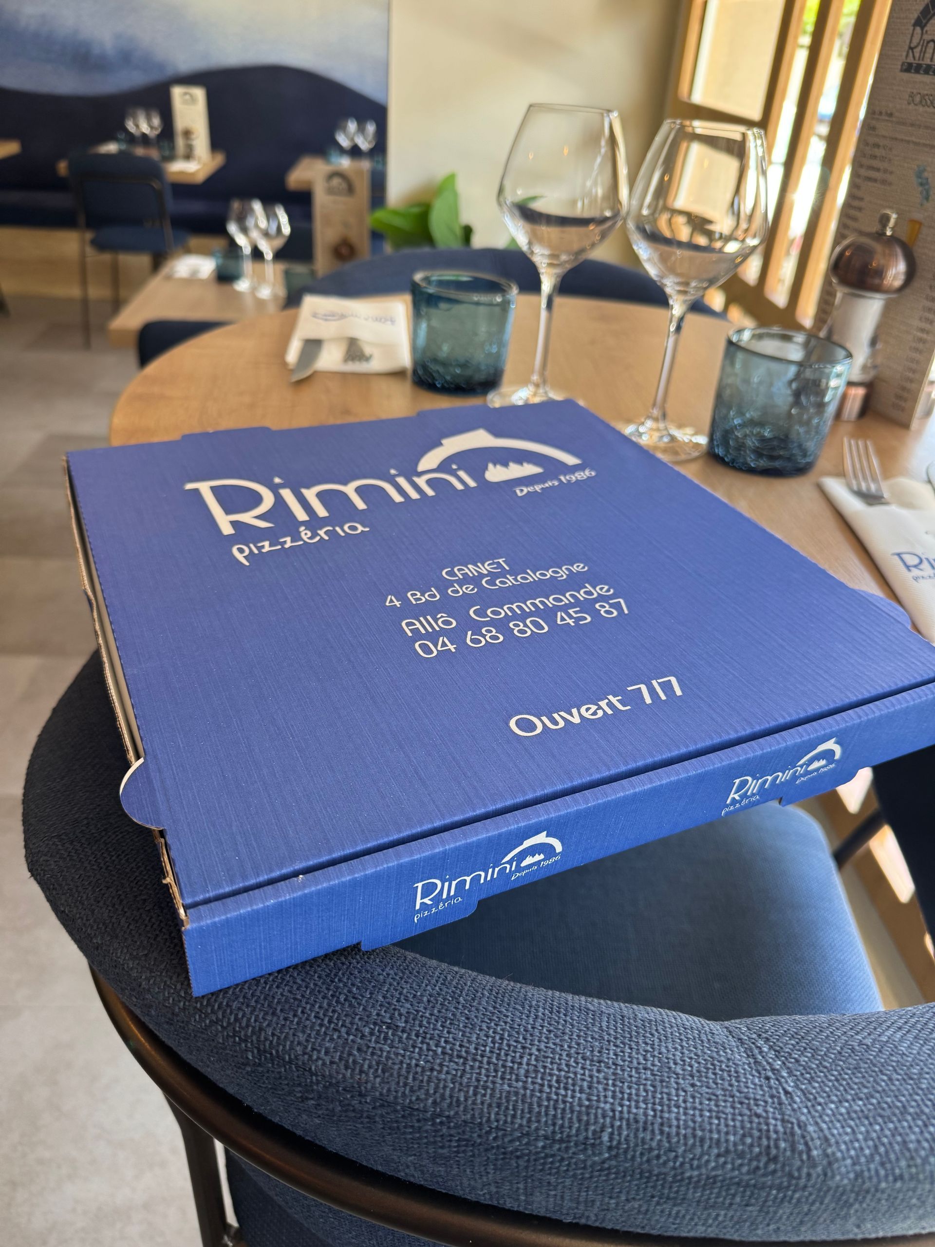 Une boîte à pizza sur un fauteuil.