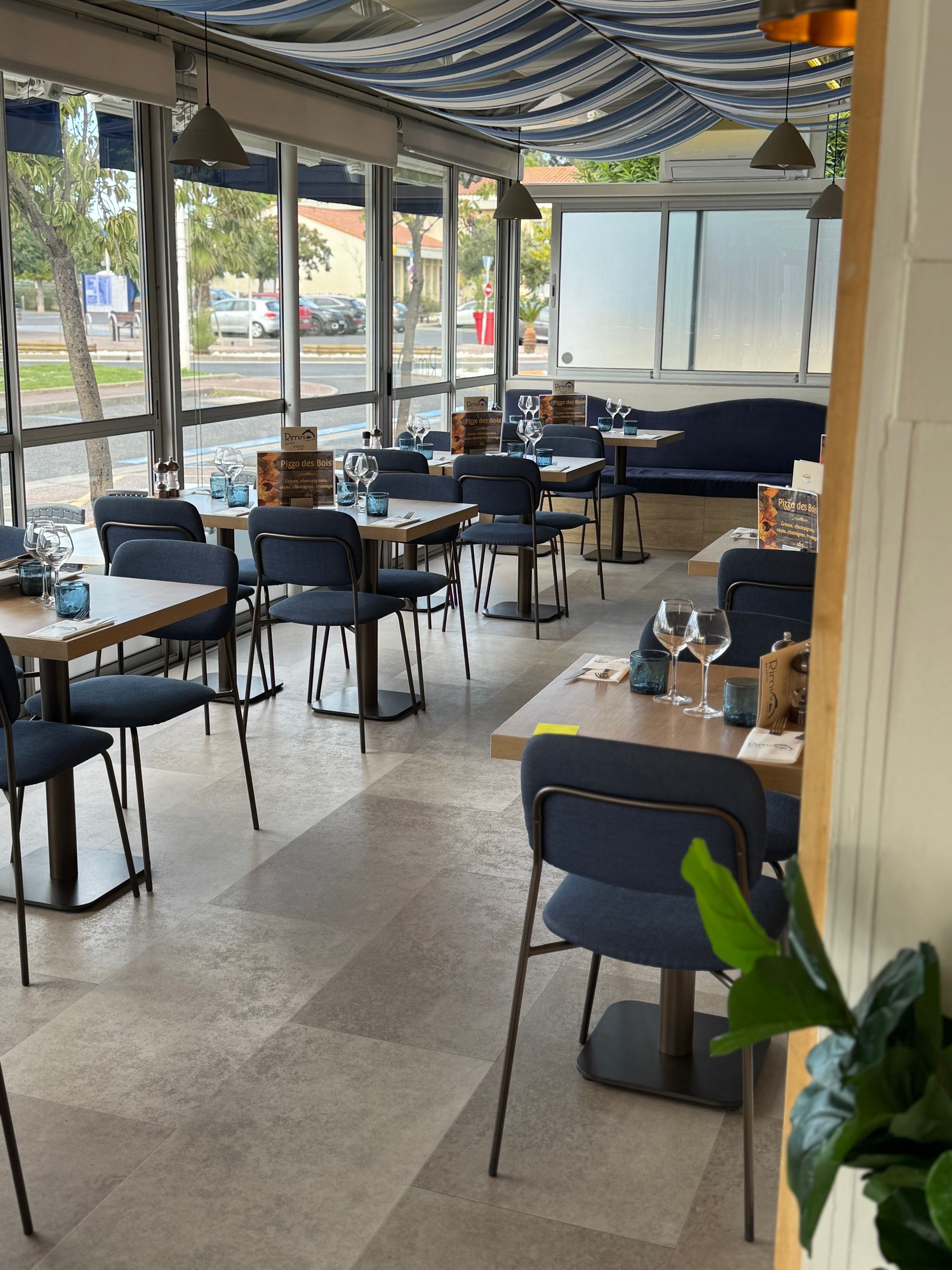 La salle du restaurant avec des chaises bleues.