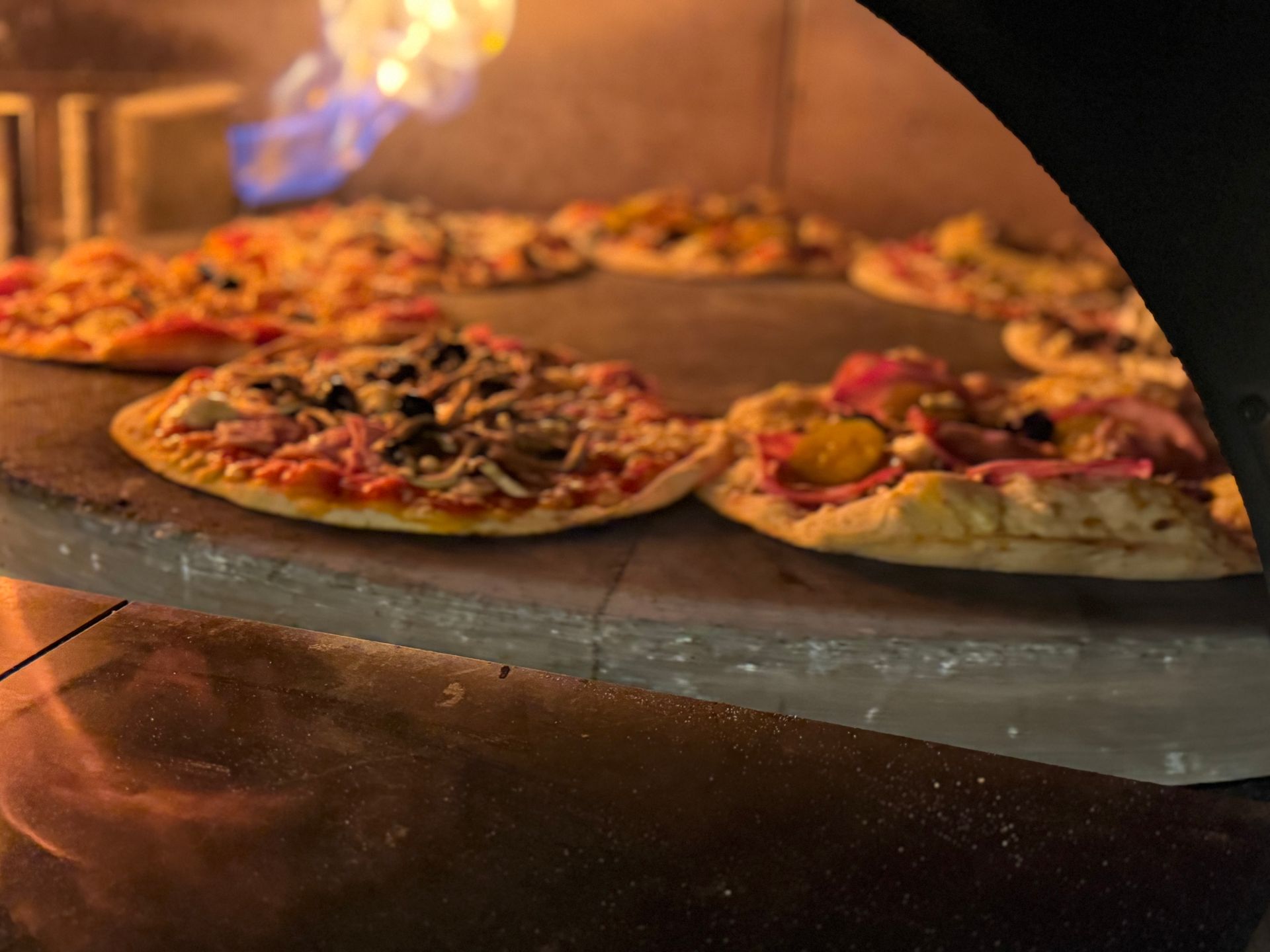 Plusieurs pizzas dans un four.