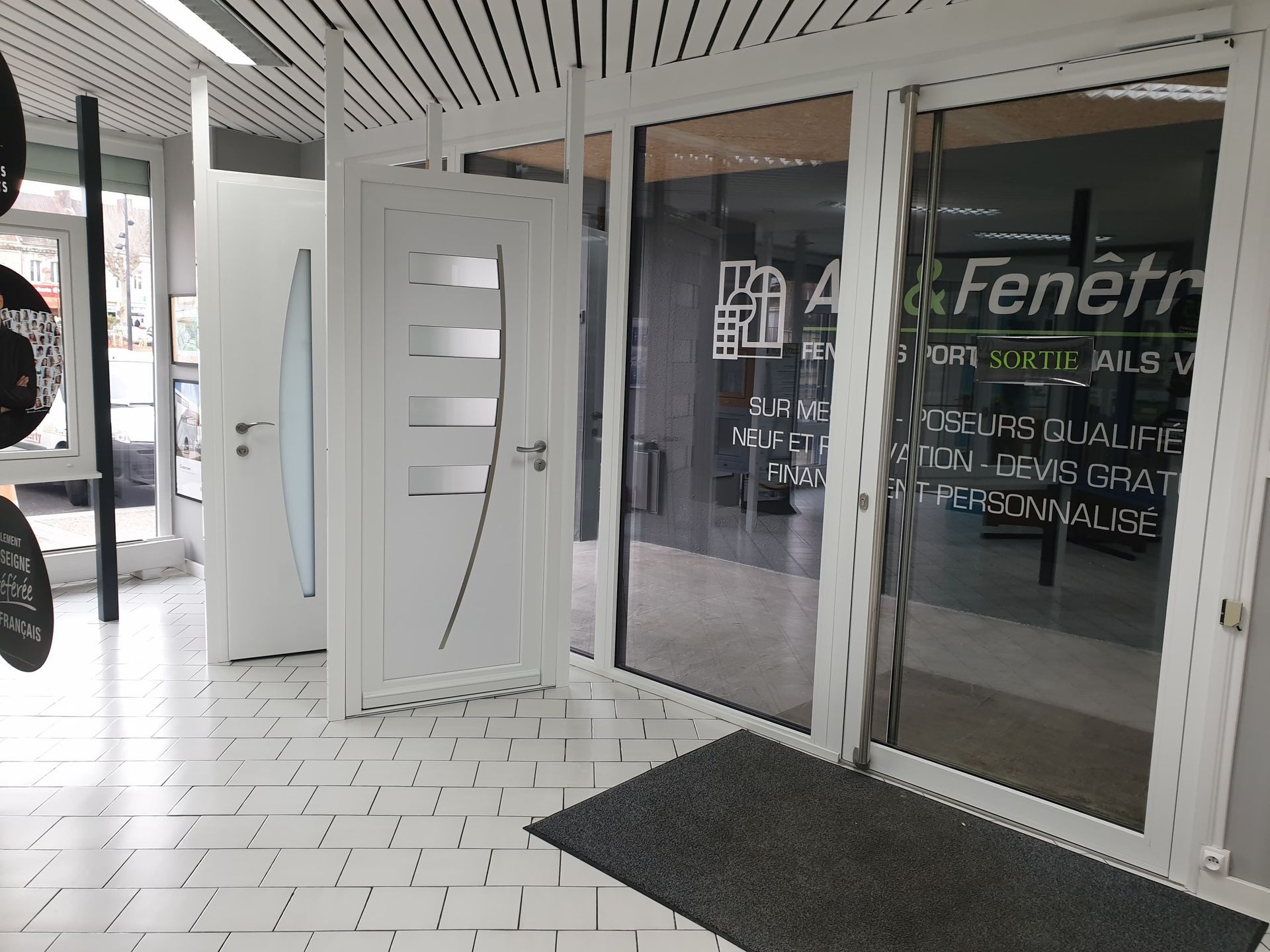 Portes et vitrines blanches dans une salle d'exposition.