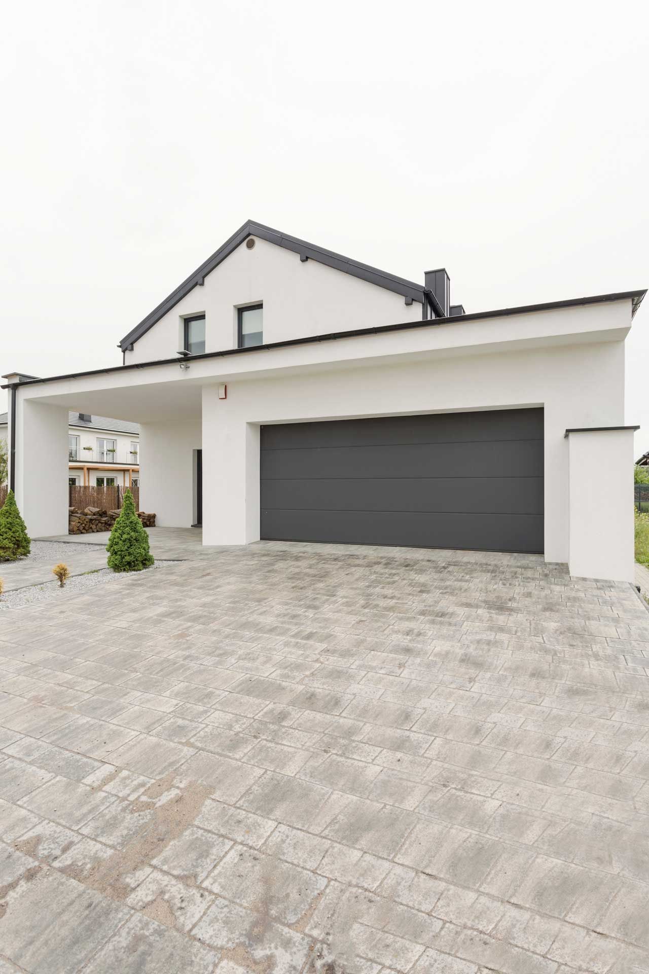 Porte de garage d'une maison avec une allée d'accès devant.