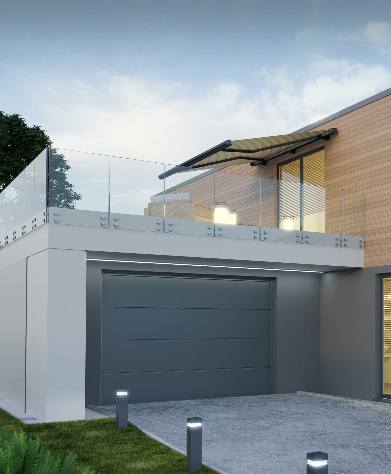 Porte de garage grise sous la terrasse d'une maison.