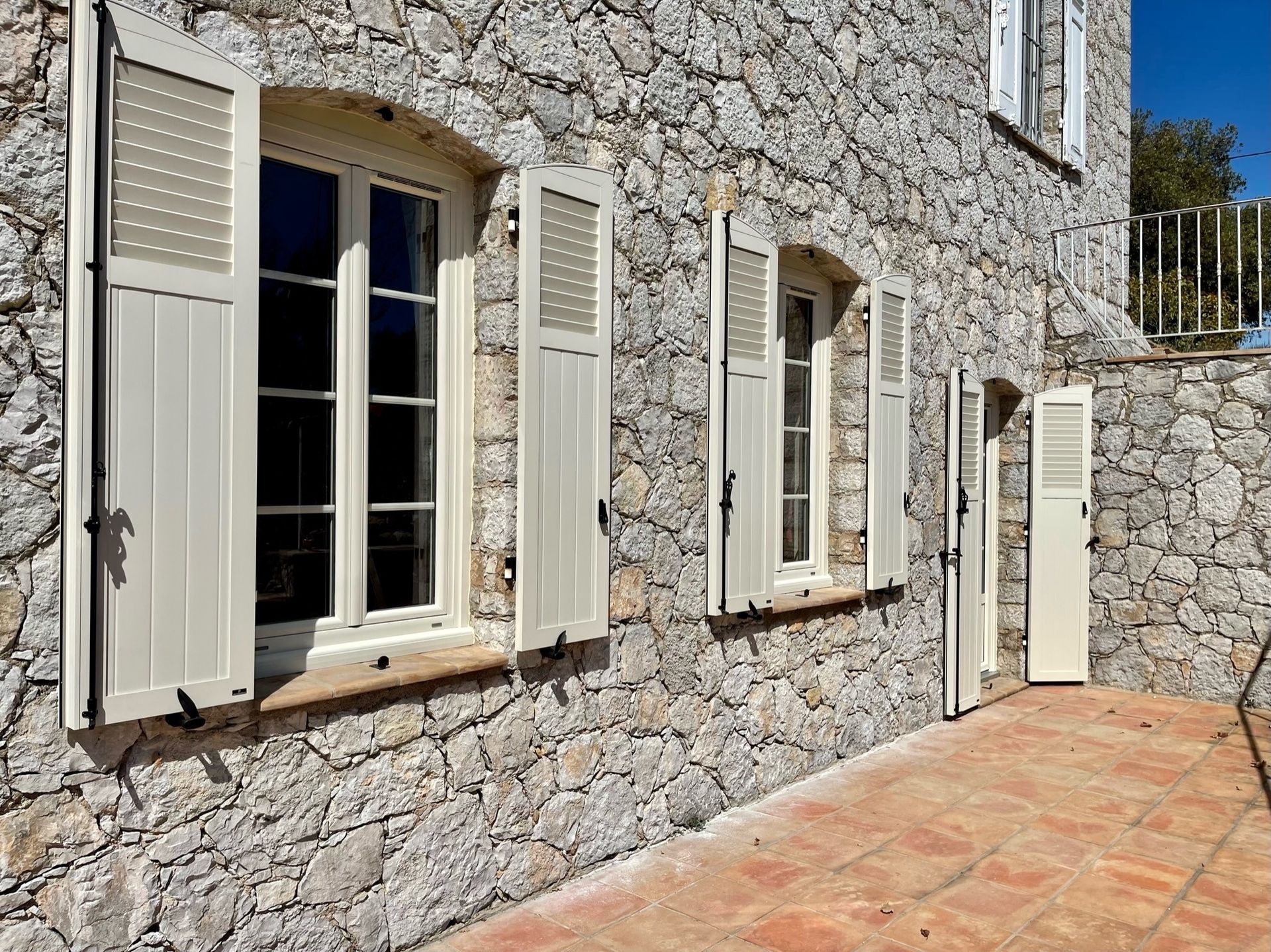 Volets battants en aluminium sur la façade d'une maison.