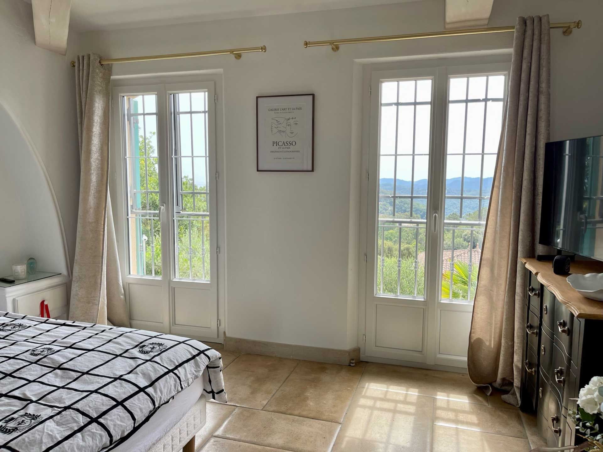 Deux portes-fenêtres, vue de l'intérieur d'une chambre.