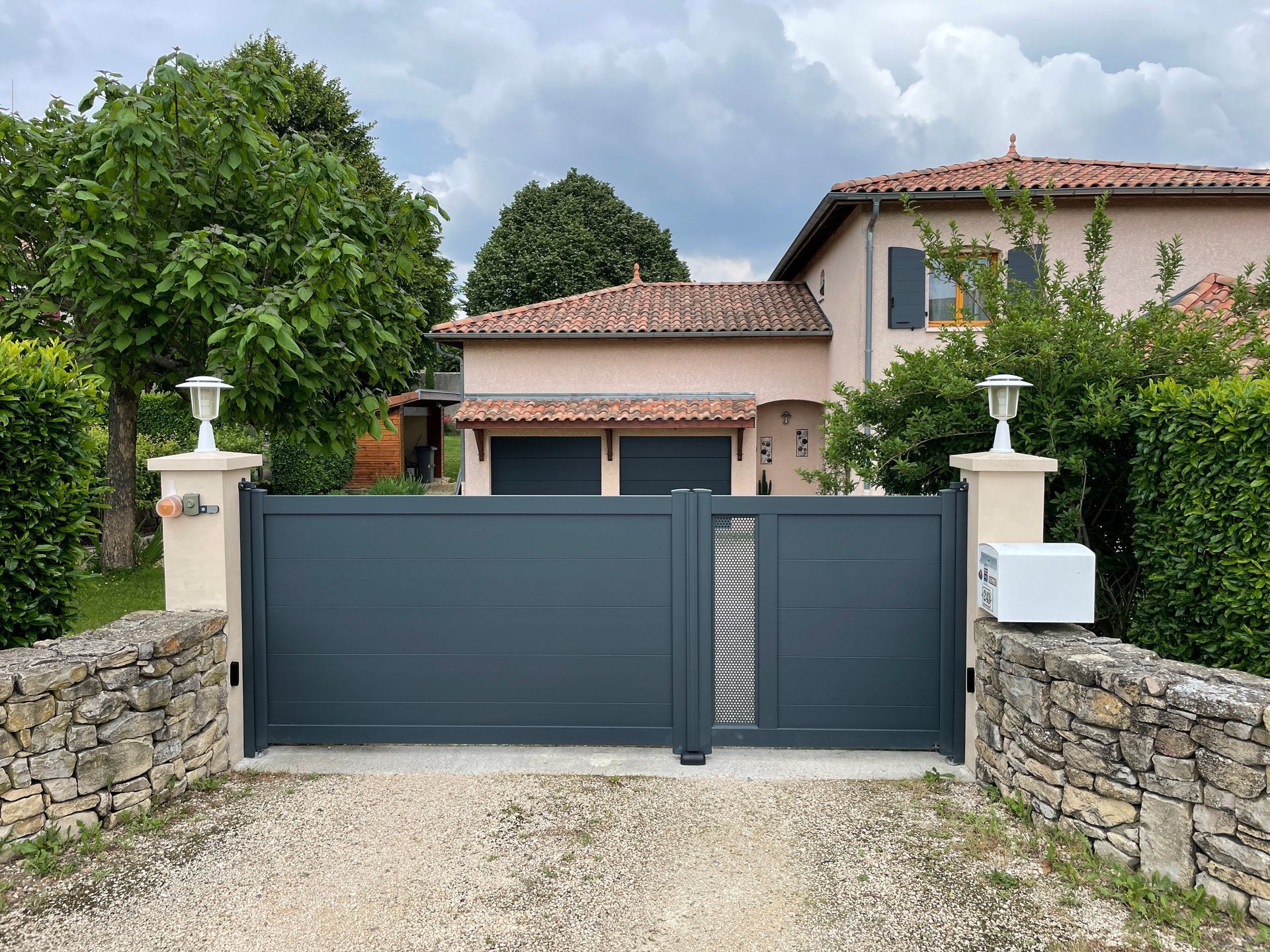 Portillon avec le portail et une maison en arrière-plan.