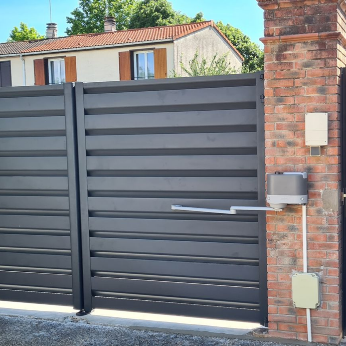 Gros plan sur le moteur d'un portail battant.