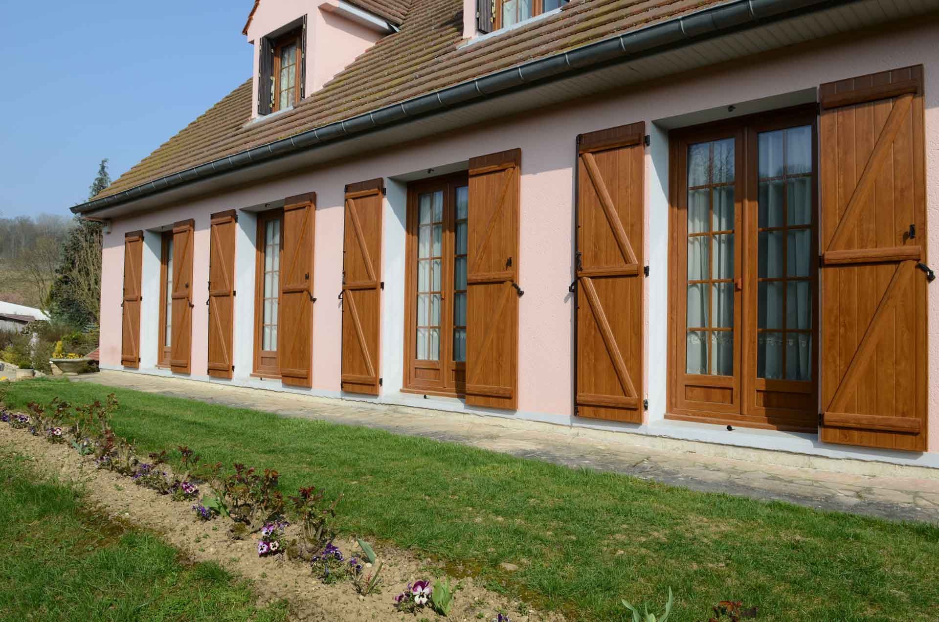 Maison de plain-pied avec les volets en bois.