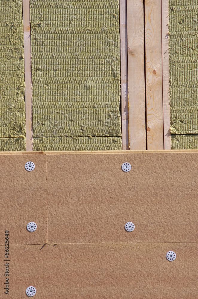 Un mur avec différentes tranches d'isolants apparentes.