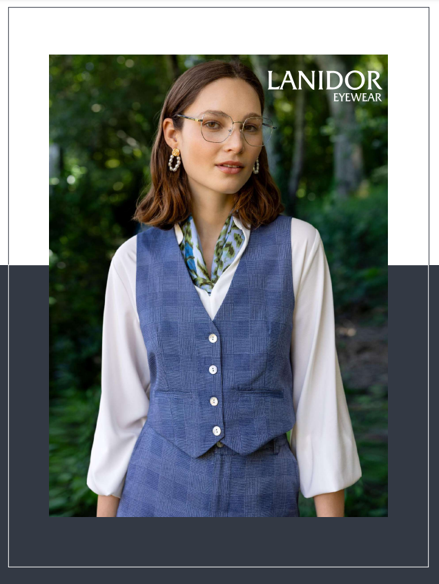 Una mujer que lleva gafas y un chaleco azul está parada en un bosque.