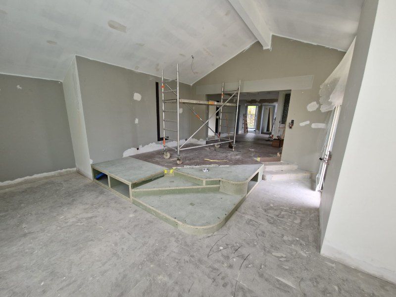 Une grande pièce avec un escalier et un échafaudage à l'intérieur.