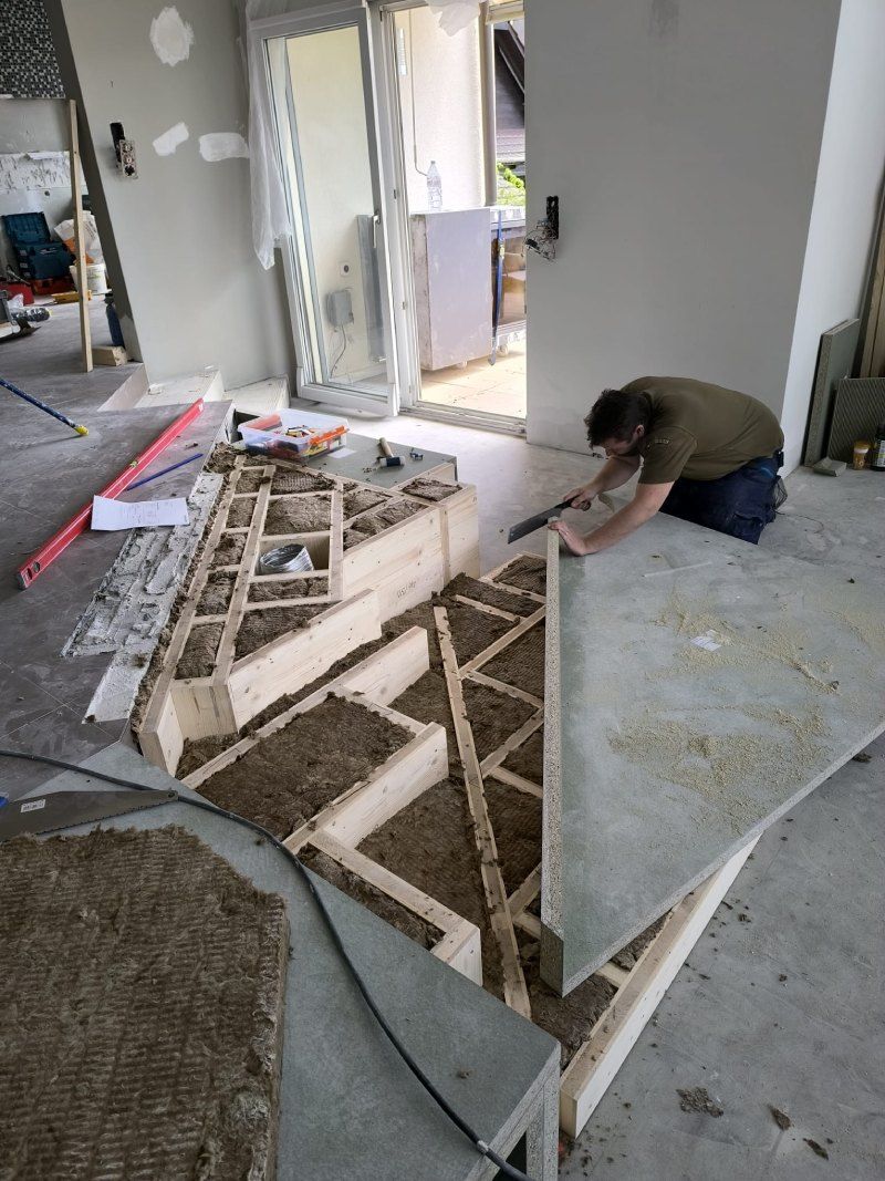 Un homme travaille sur une structure en bois dans une pièce.