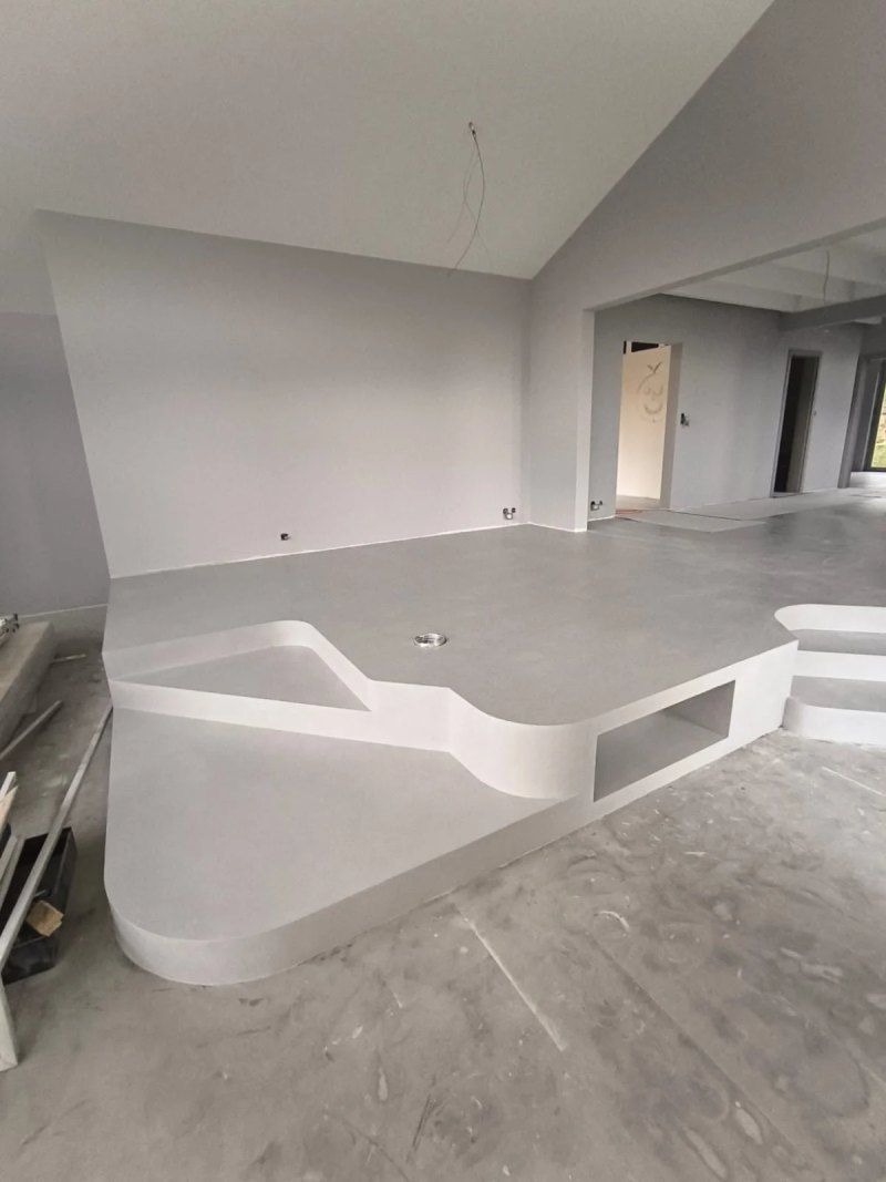 Une grande pièce vide avec un sol en béton et des escaliers.