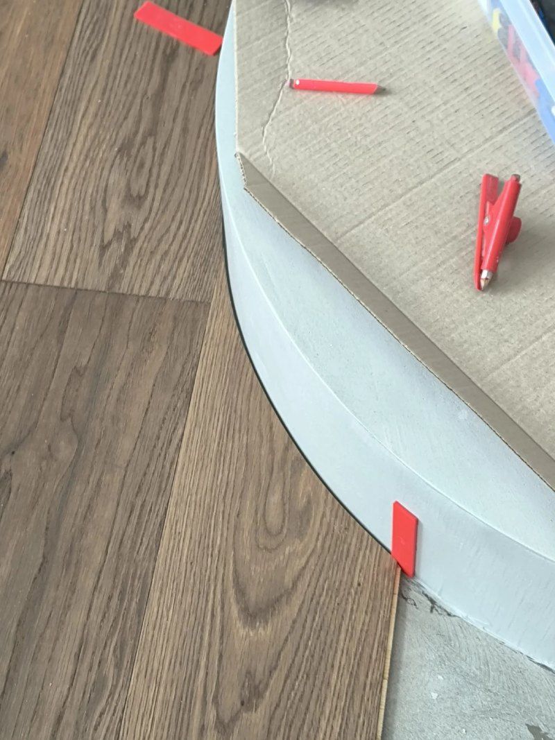 Un gros plan d'un plancher en bois avec des marqueurs rouges dessus.