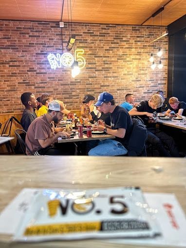 Un groupe de personnes sont assises à des tables dans un restaurant.