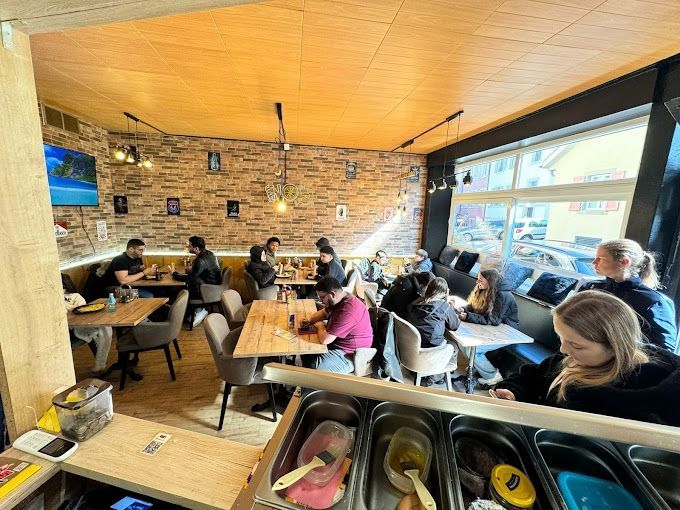 Un groupe de personnes sont assises à des tables dans un restaurant.
