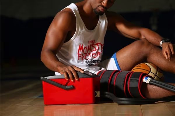 Joueur de basket-ball utilisant un appareil de thérapie par le froid à côté d'une glacière sur le terrain