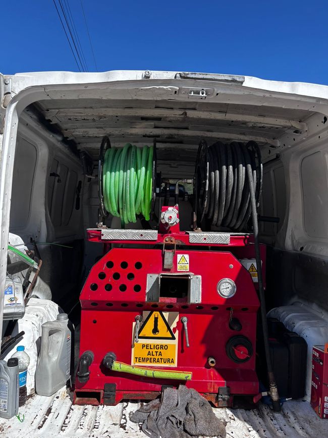 Equipo profesional de desatascos trabajando junto a una furgoneta de servicio