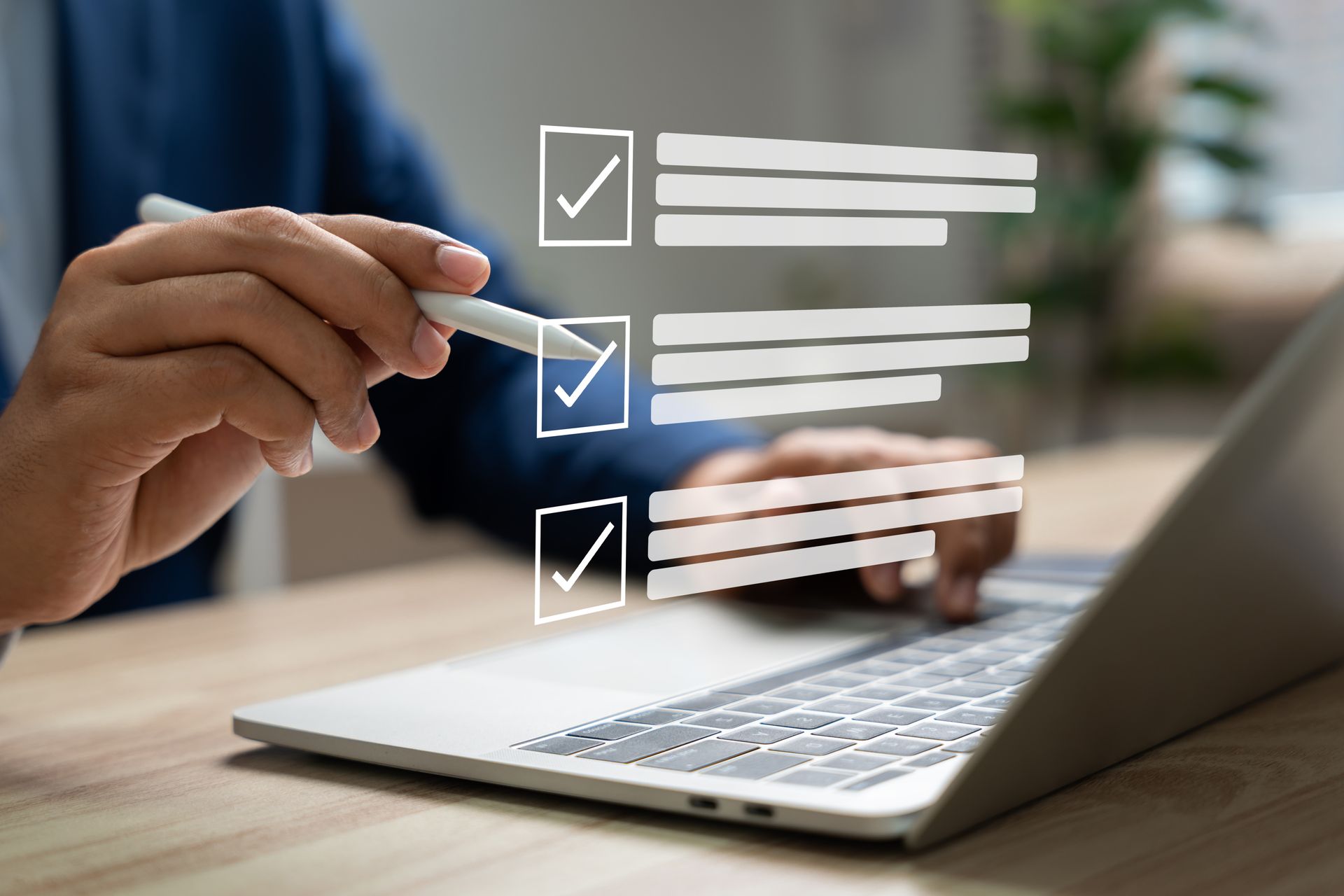 Des mains cochant des cases sur une liste transparente à côté d'un ordinateur portable sur un bureau.