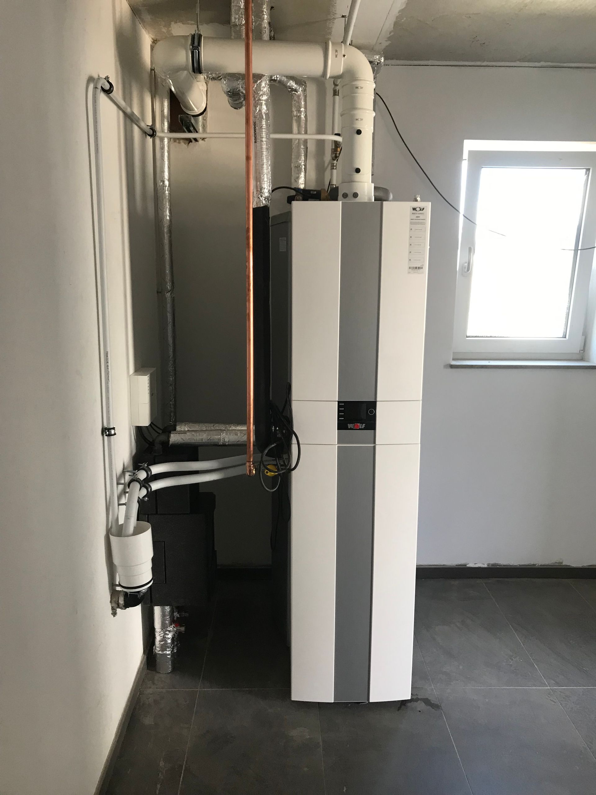 Blaue Industrierohre mit Ventilen und Manometern.