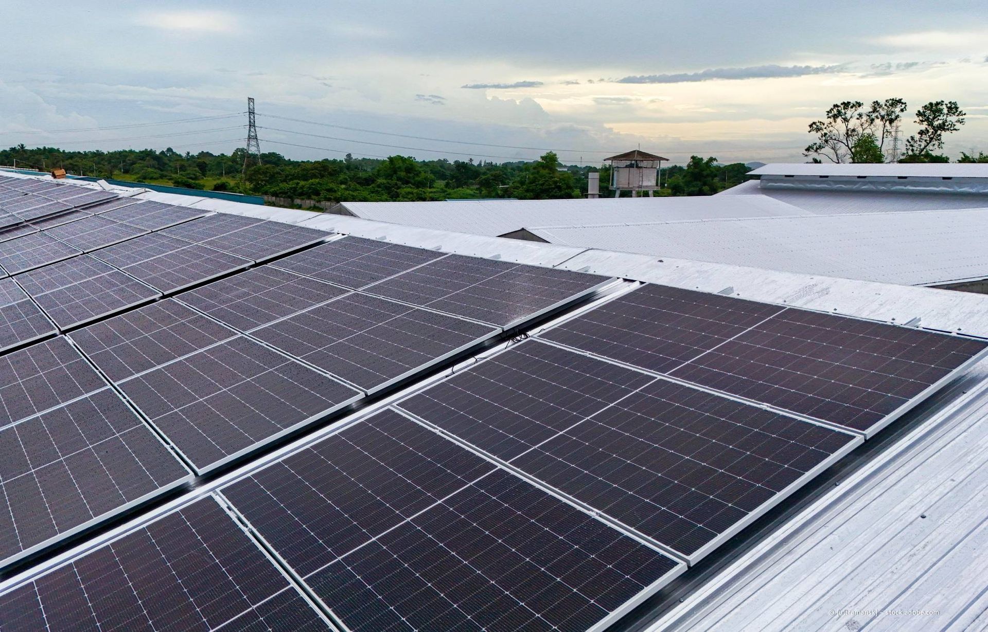 Solarpaneele auf einem Gebäudedach erzeugen erneuerbare Energie. Bewölkter Himmel im Hintergrund.