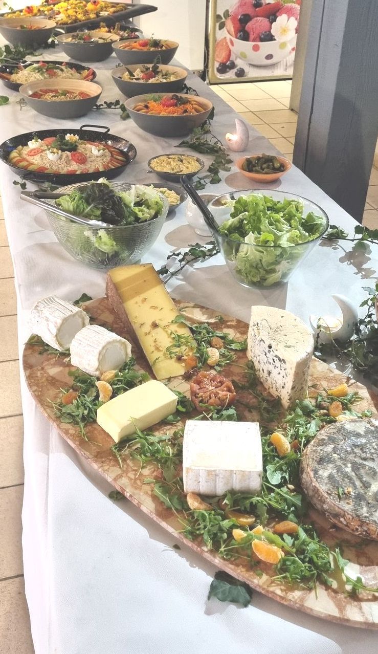 Plateau de fromage avec saladiers de salade à côté