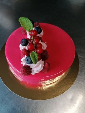 Gâteau recouvert d'une sauce aux fruits rouges avec fruits et chantilly dessus