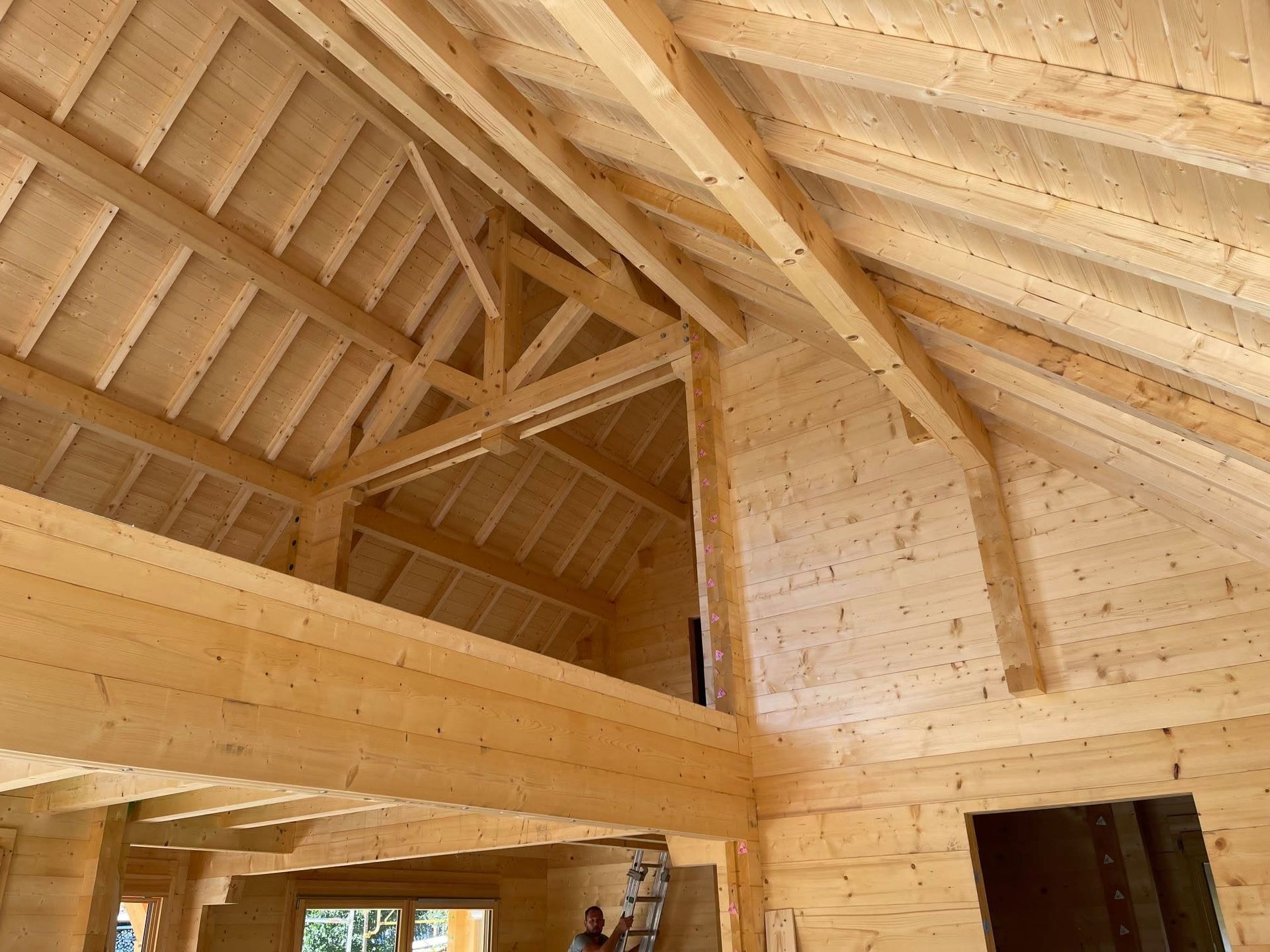 Intérieur d'une pièce en bois mansardée avec un étage.
