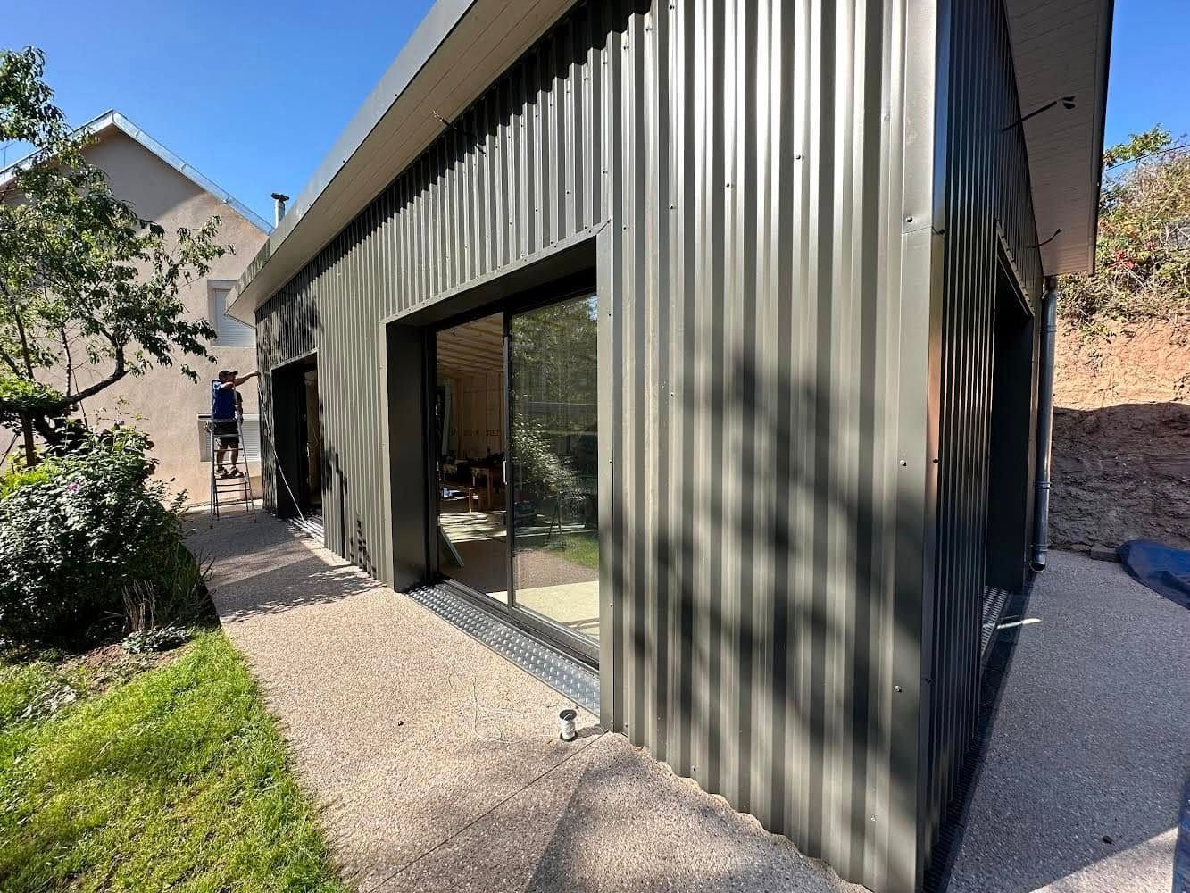 Une maison avec un bardage métallique.