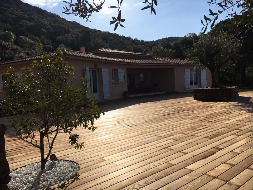 Une terrasse en bois près d'une maison.