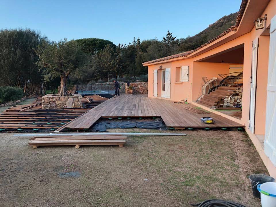 Construction d'une terrasse en bois, attenante à une maison.