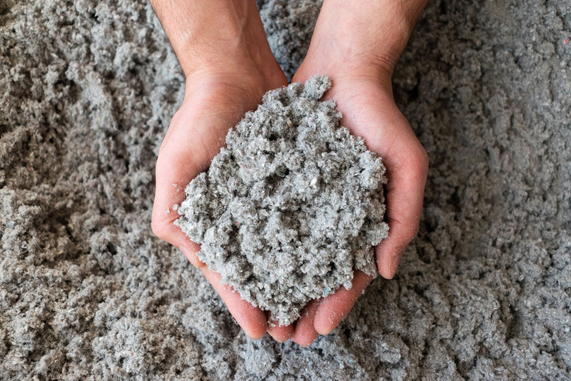 Des mains tenant de la ouate de cellulose.