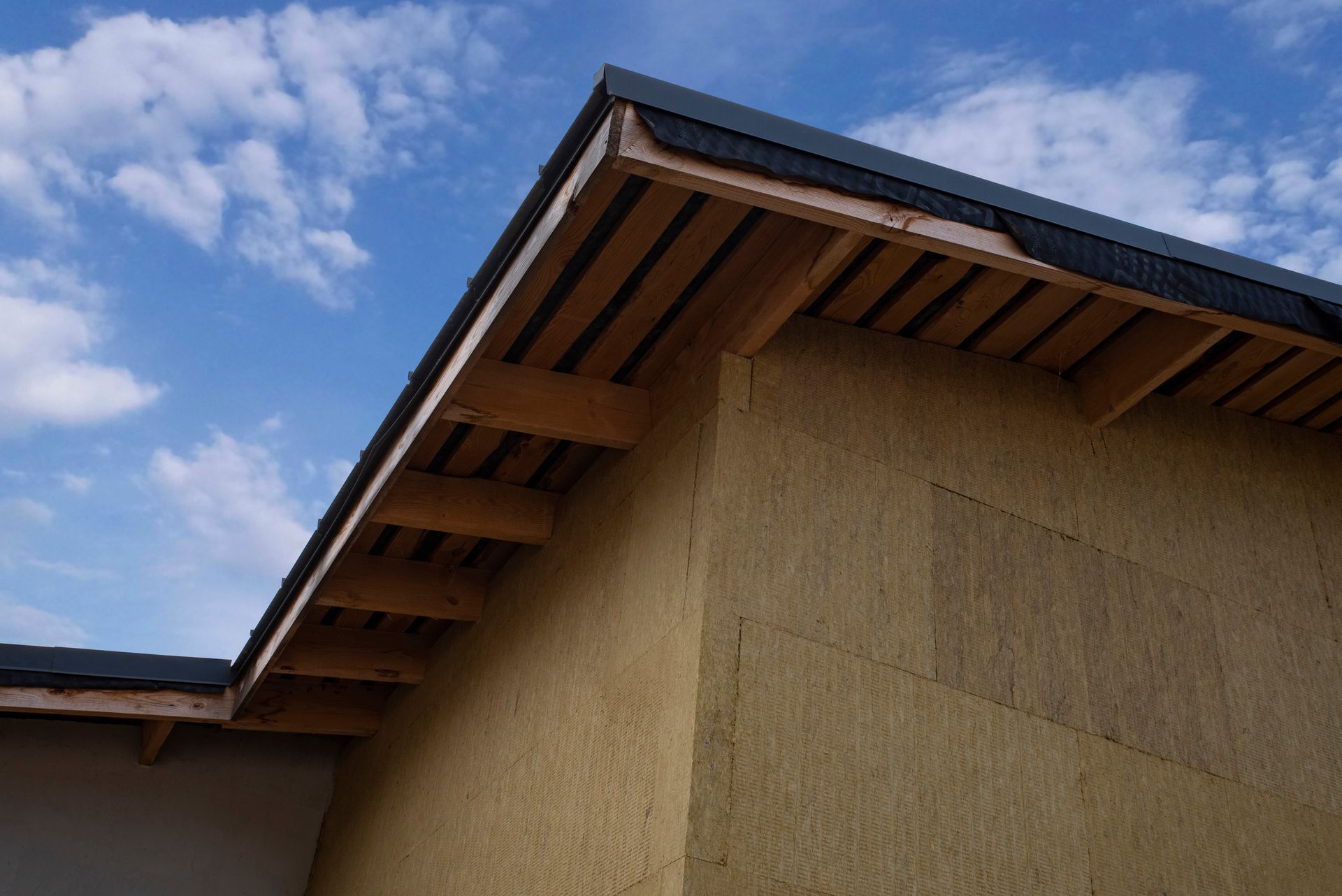 Façade d'une maison recouverte de panneaux de fibres de bois.