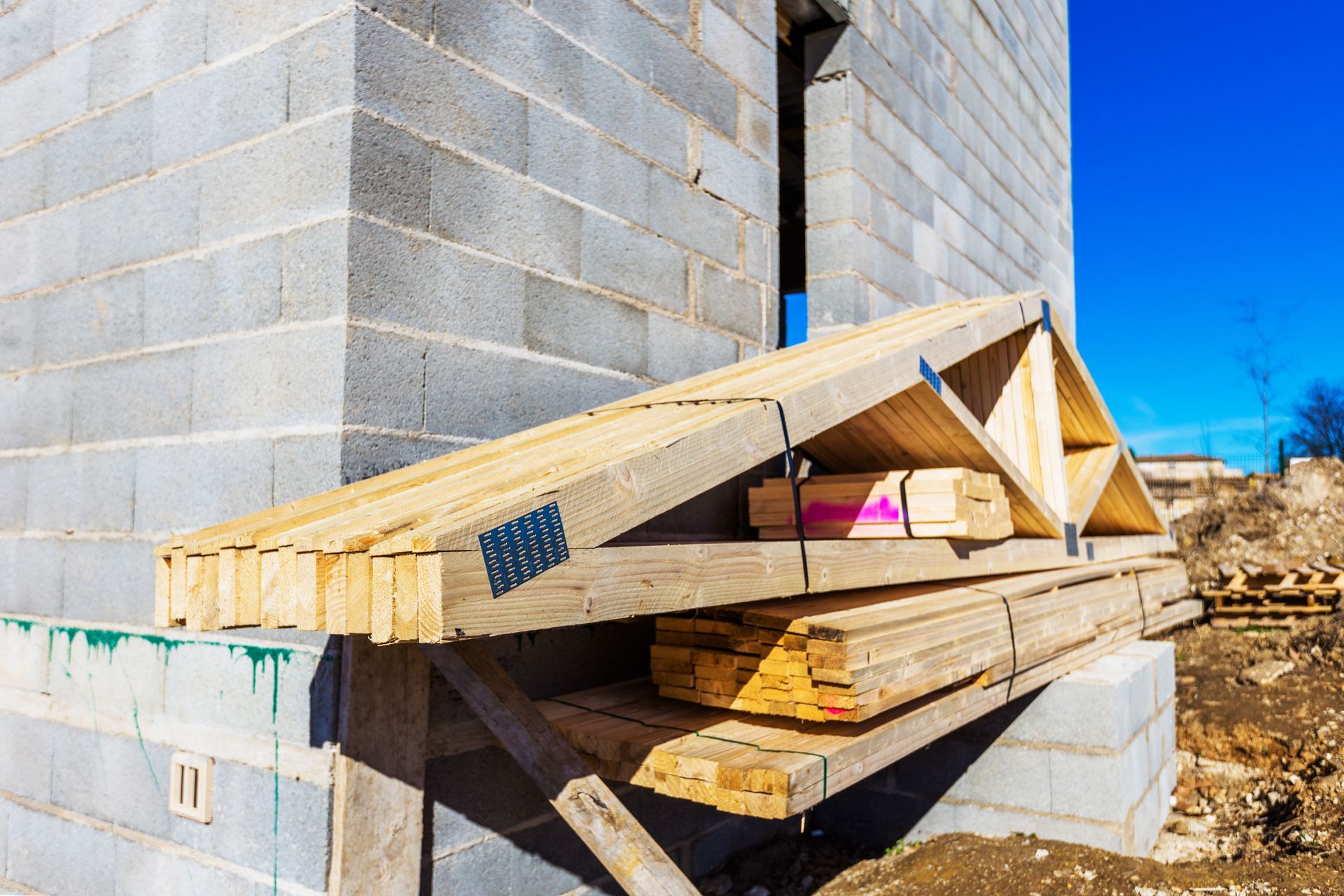 Des fermettes posées sur le côté d'une construction en parpaings.