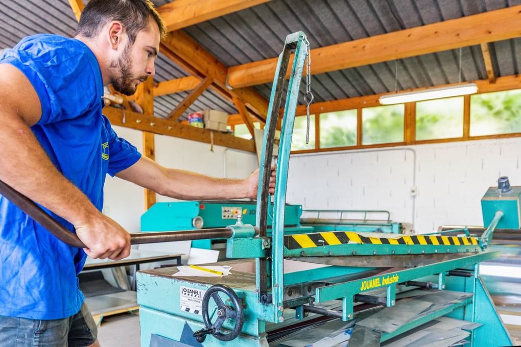 Un couvreur qui manipule une machine.