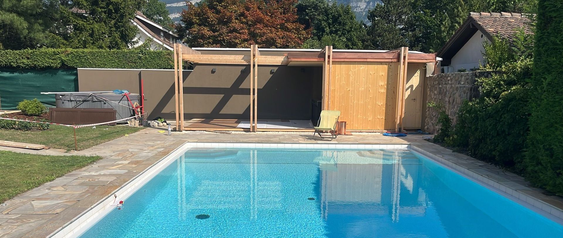 une palissade en bois avec une piscine devant