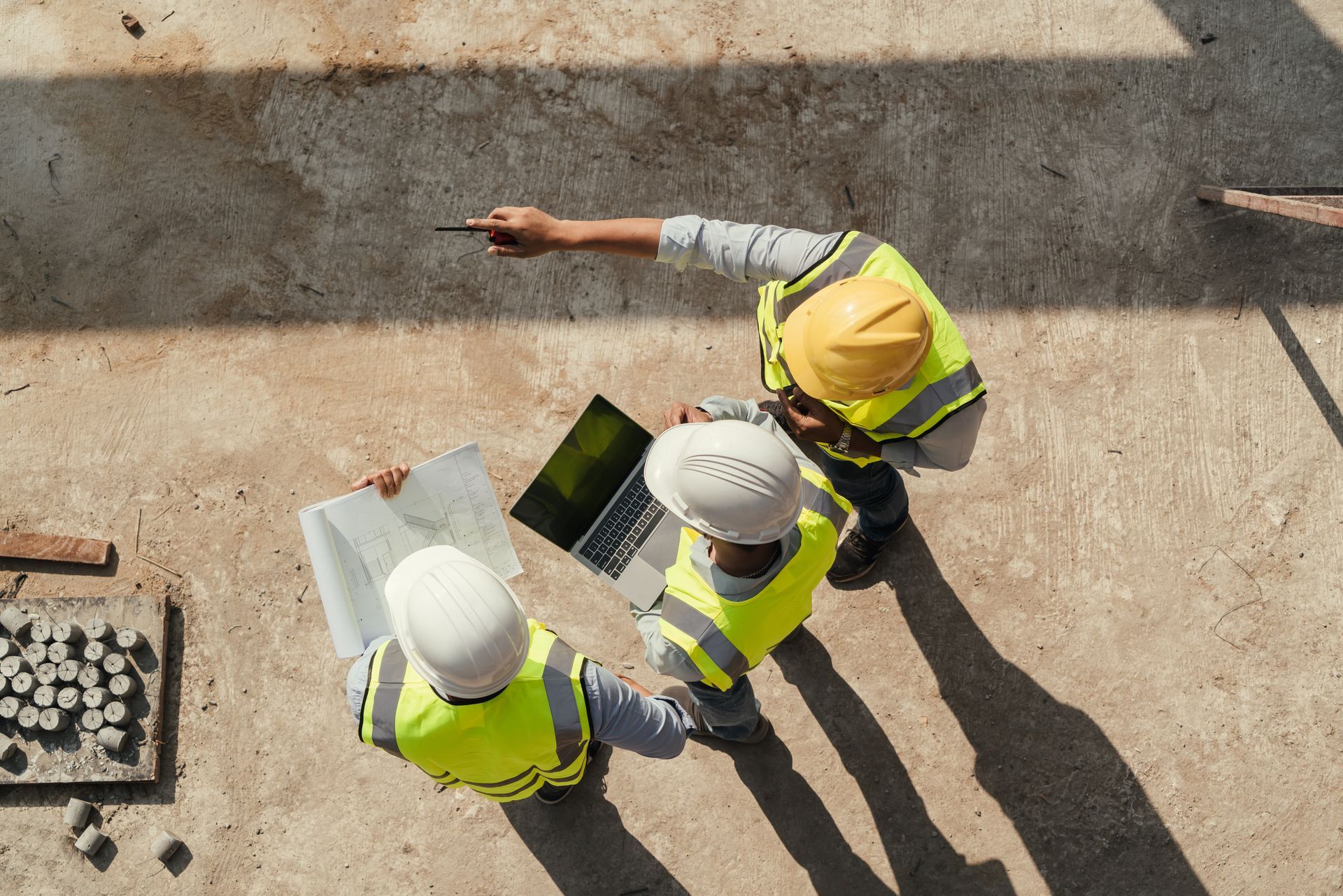 Trois hommes avec un casque de chantier.