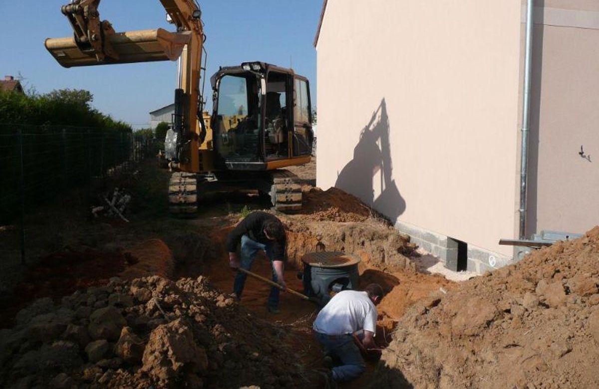 Professionnels réalisant la pose d'une fosse toutes eaux