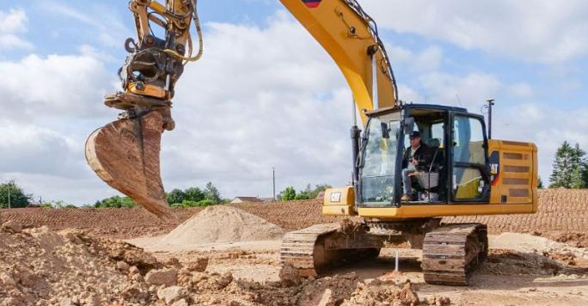 Pelleteuse et ouvrier portant un casque de chantier