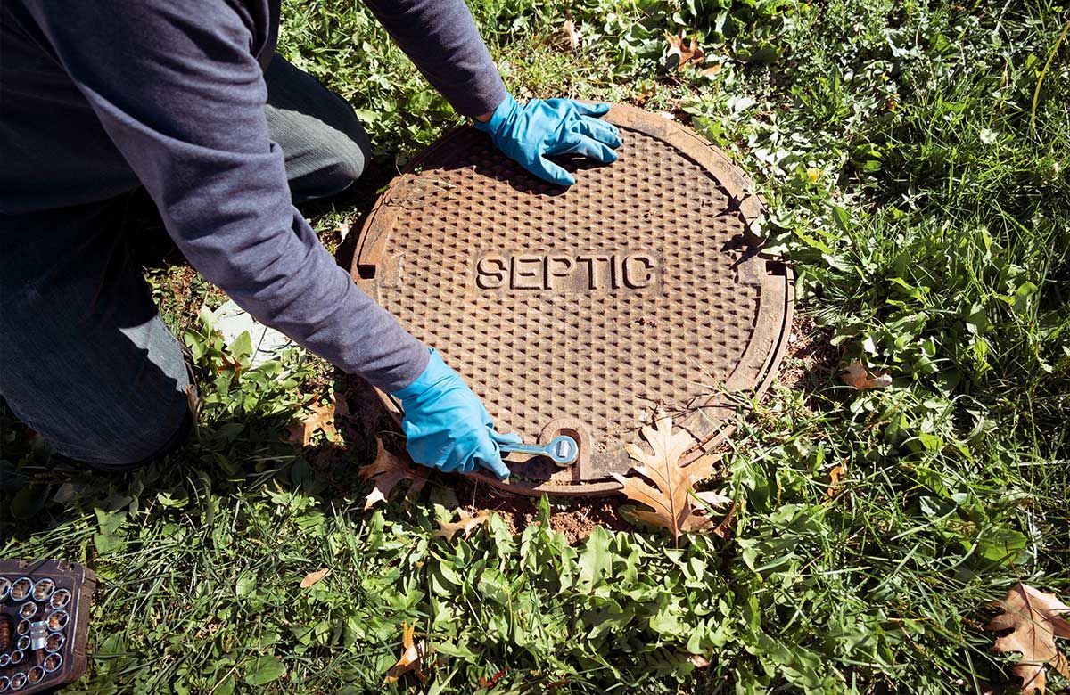 Mains posées sur une bouche d'égout 