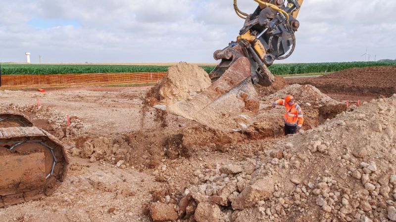 pelleteuse retournant la terre d'une tranchée