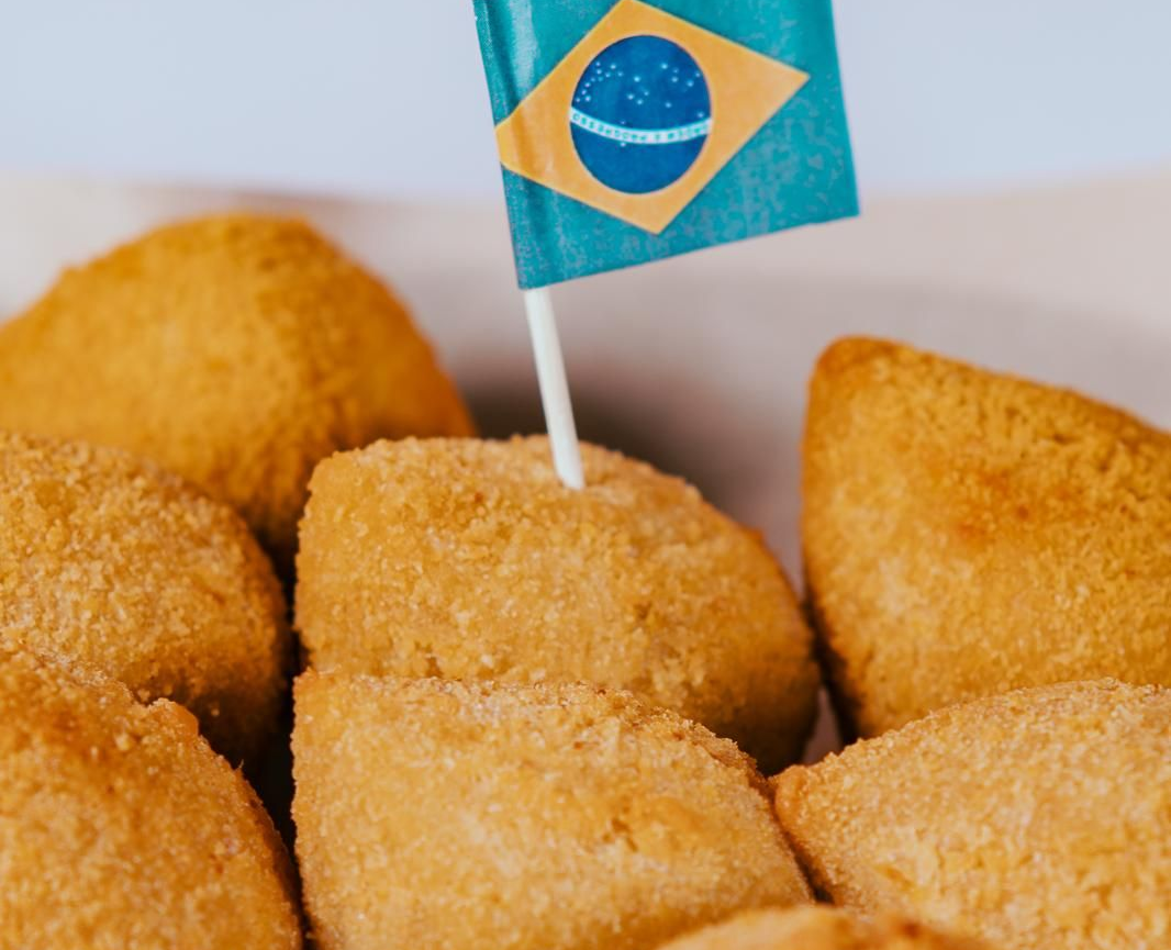 Snacks fritos brasileños con una pequeña bandera brasileña.