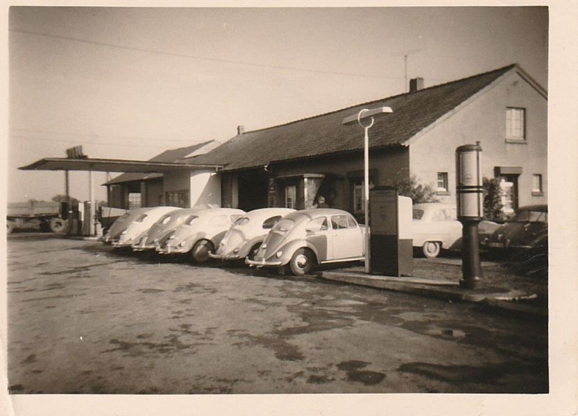 Ein Schwarzweißfoto von vor einem Gebäude geparkten Autos