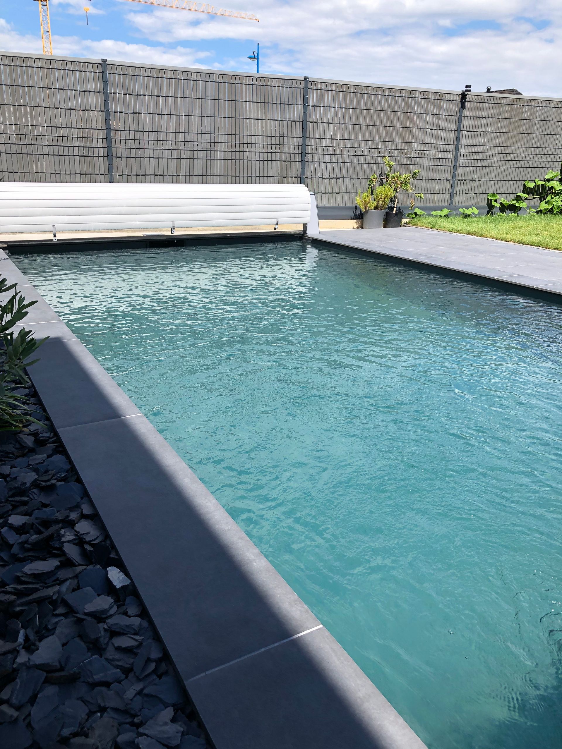 Piscine avec margelles en béton à proximité de clôtures