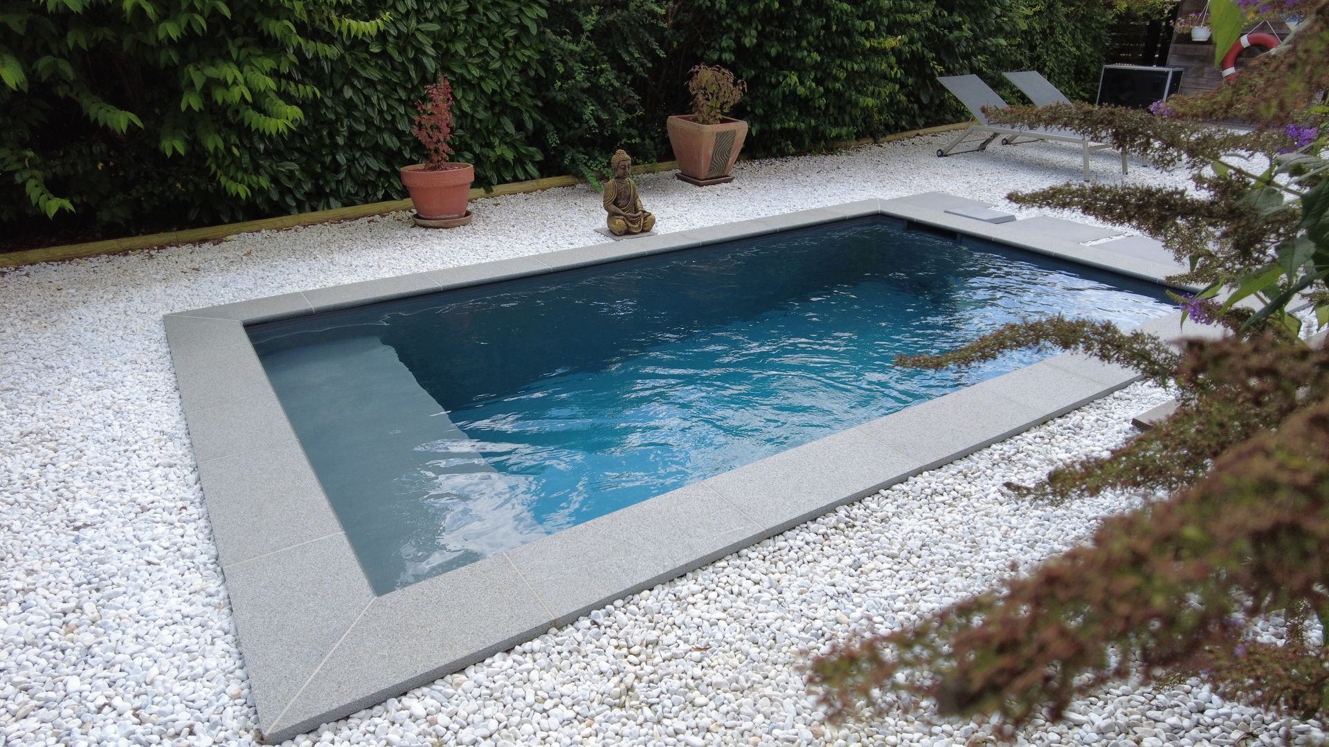 Piscine avec tour en cailloux blancs.