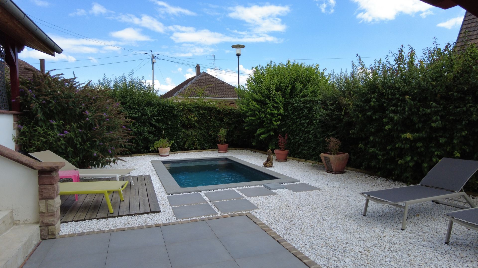 Piscine avec tour en cailloux blancs.