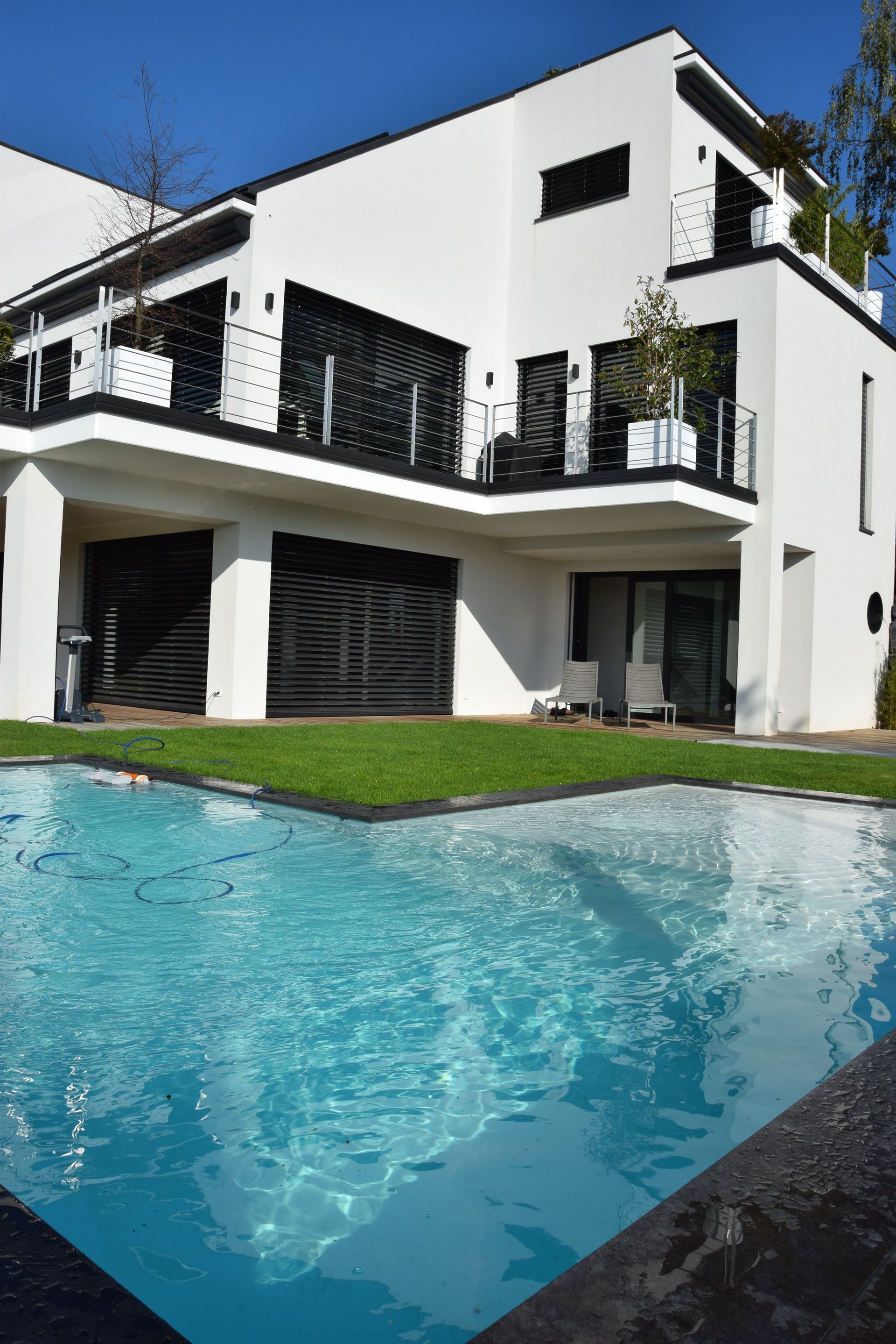 Piscine en L avec un tuyau dans l'eau.