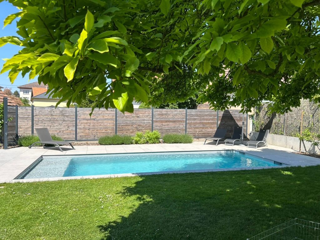 Piscine à l'ombre d'un arbre, un jour de beau temps.