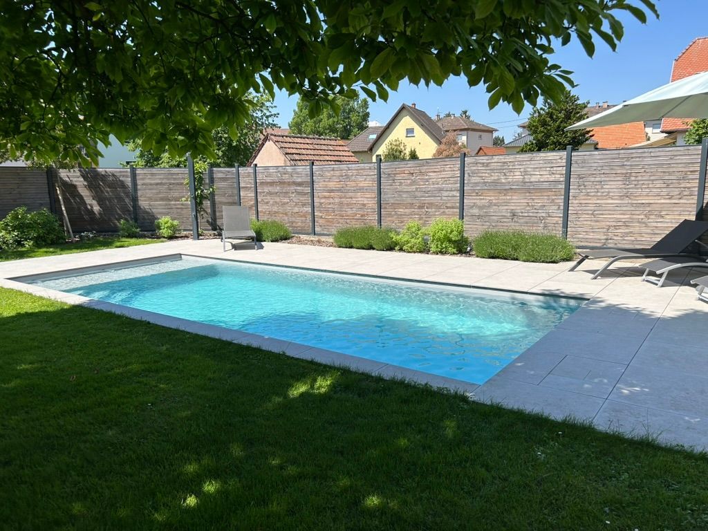 Piscine près d'une pelouse.