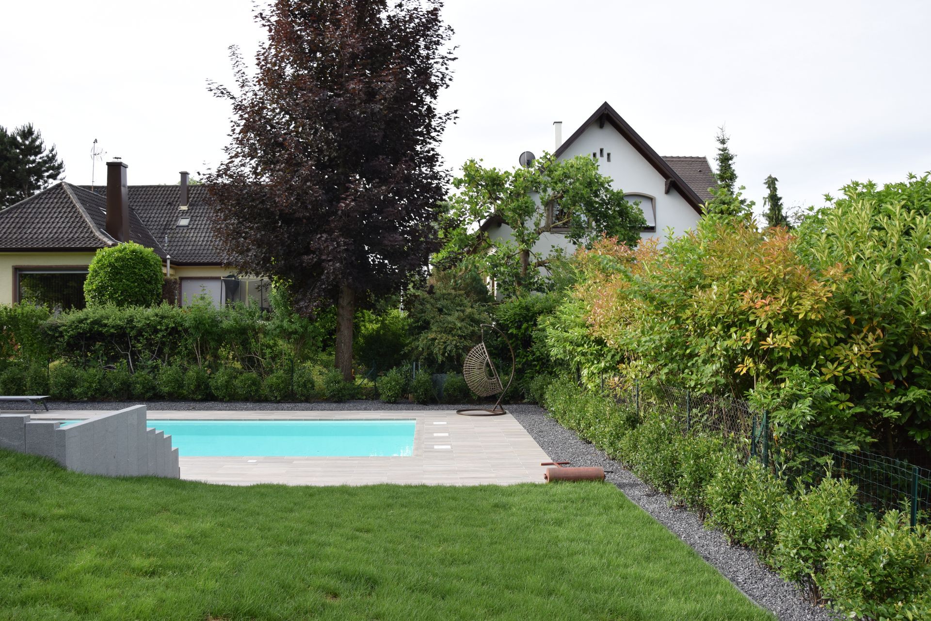 Jardin donnant sur une terrasse avec une piscine.
